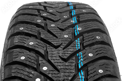 Close-up of winter tire tread with studs for passenger car on white