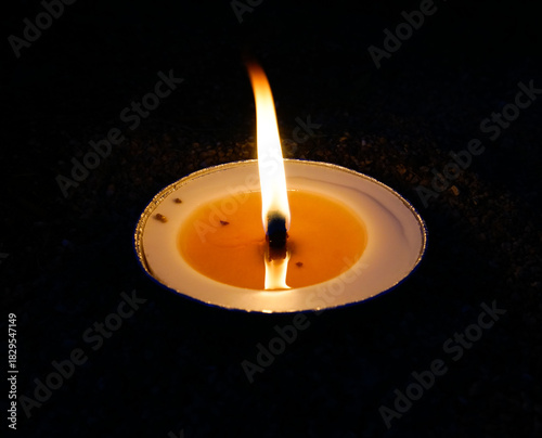 burning candle on black background
