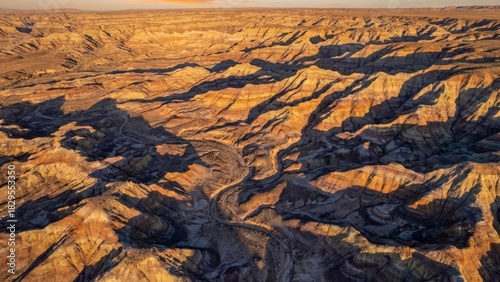 Aerial view of a dry canyon landscape with winding riverbed at sunset in arid environment region