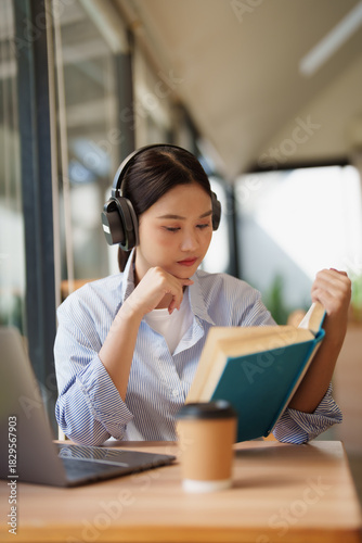 Young woman learning and studying with headphones and book