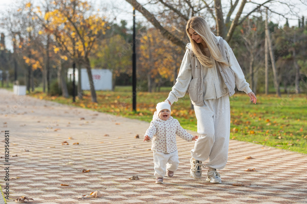 Obraz premium A beautiful woman walks in the park with a child 