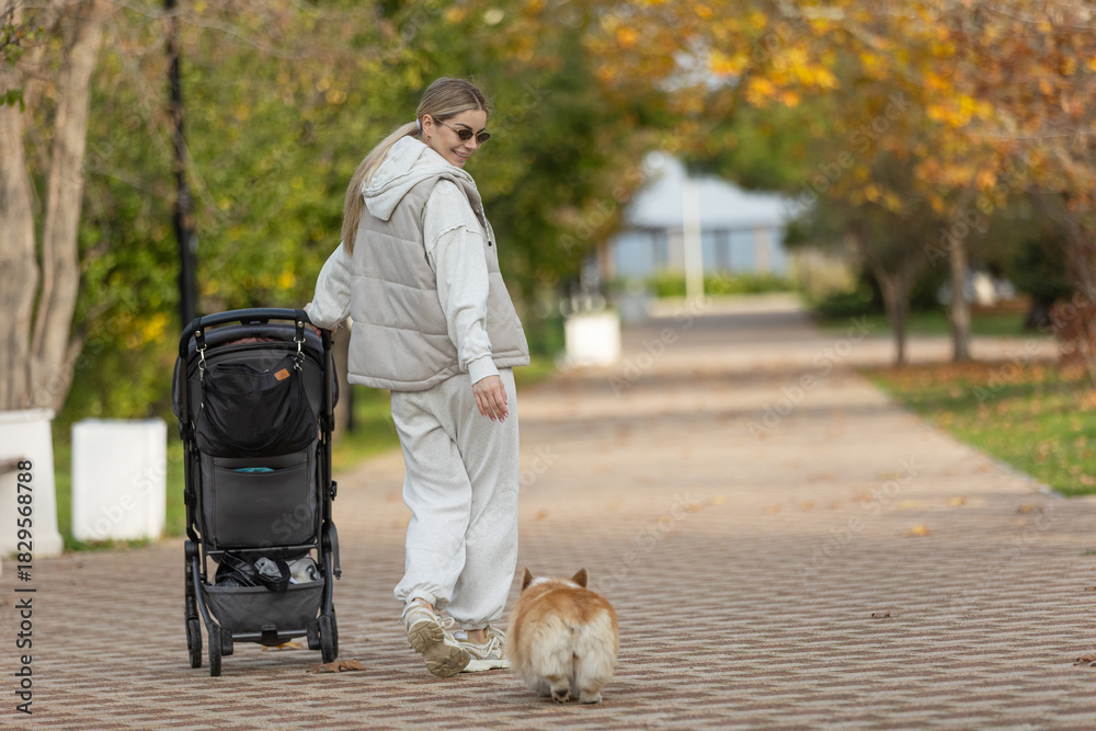 Fototapeta premium A beautiful woman walks in the park with a child 