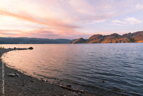 Sunset view of the beach and mountains at Okanagan Lake Provincial Park