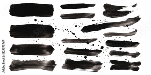 Abstract black ink brush strokes and paint splatters on pure white surface.