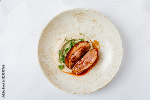 A beautifully plated dish features tender duck breast, creamy sauce, and fresh microgreens