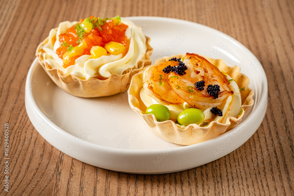 Fototapeta premium Colorful tartlets filled with cream and toppings, showcasing a blend of sweet and savory flavors
