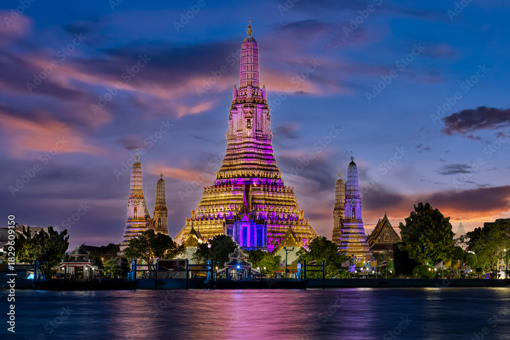 Fototapeta premium 26 November 2025 Beautiful Sunset colours of Thai Temple Wat Arun on Chao Phraya River in BKK Bangkok Thailand. The magic colourful neon light display on the temple at sunset is magical.
