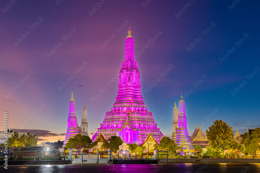 Fototapeta premium 26 November 2025 Beautiful Sunset colours of Thai Temple Wat Arun on Chao Phraya River in BKK Bangkok Thailand. The magic colourful neon light display on the temple at sunset is magical.