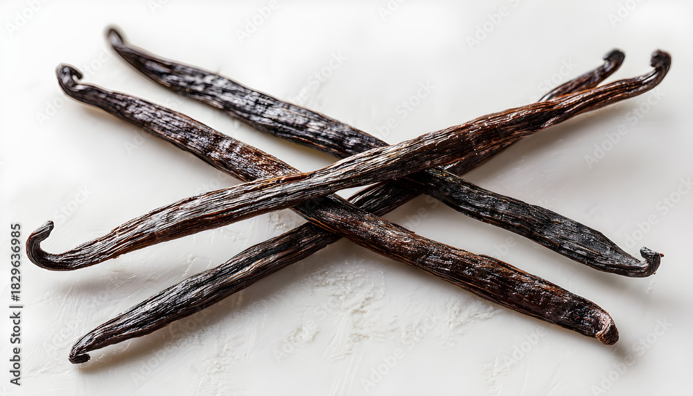 Obraz premium Three vanilla pods arranged on a white surface