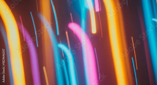 Abstract motion blur of vibrant neon light trails in orange, pink, and blue, creating a dynamic, futuristic background