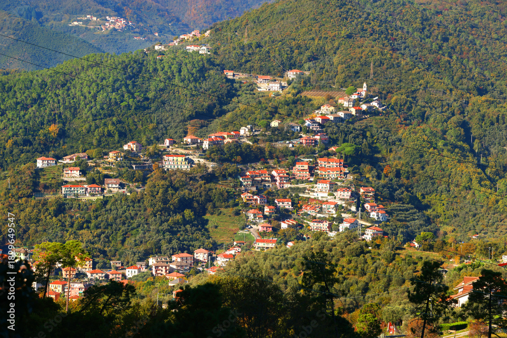 Fototapeta premium Traditional buildings, mountain houses. The nature and architecture of Liguria. Blue skies, clouds, and a backdrop for design.
