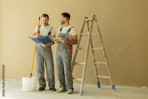 Two workers discussing plan...