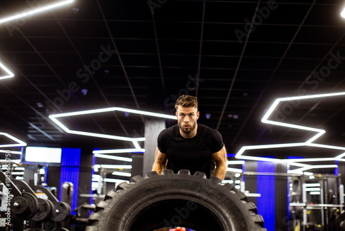 Man lifts large tire in mod...