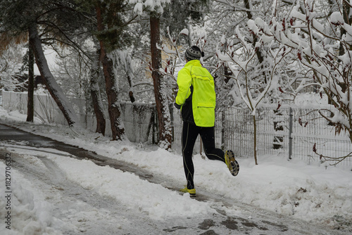 dorosła osoba uprawiająca jogging w zimowy śnieżny dzień