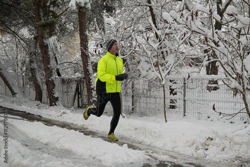 dorosła osoba uprawiająca jogging w zimowy śnieżny dzień