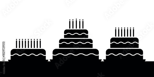 Three tiered birthday cakes with candles in silhouette