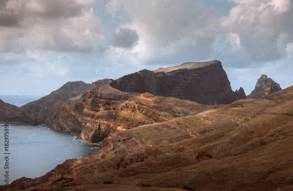 Obraz premium Dramatic volcanic cliffs and serene ocean view at Ponta de São Lourenço, Madeira Island, Portugal – panoramic coastal landscape with sailboats, hiking trails, and wild natural beauty.