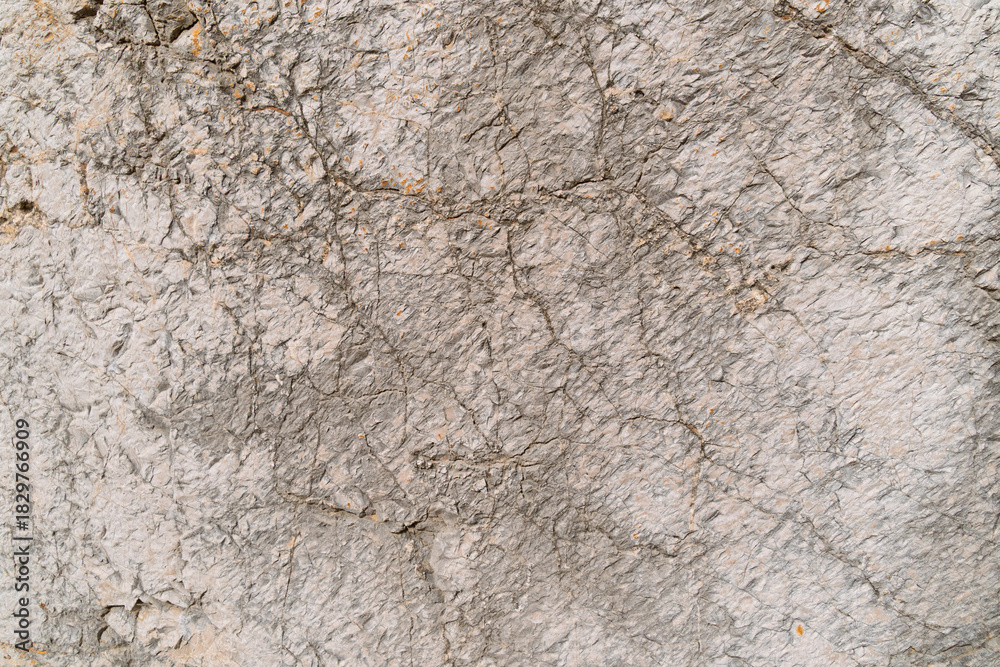 Fototapeta premium Close-up of rough gray concrete wall texture with cracks