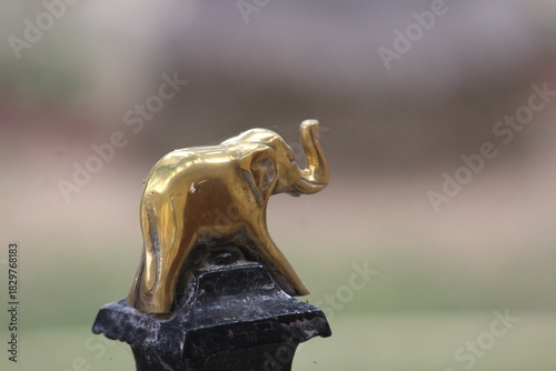 Small Golden elephant on a black metal pole