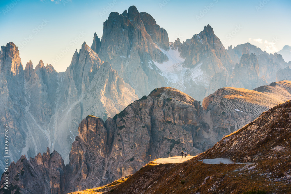 Fototapeta premium Alpine landscape of Cadini di Misurina mountain peak and hiker walking on mountain pass in Tre Cime di Lavaredo, Dolomites, Italy