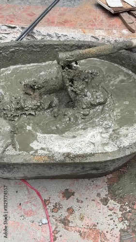 Worker Using Hoe to Mix Cement Mixture to Make Concrete. Vertical Footage