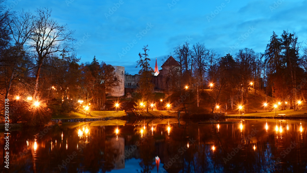 Obraz premium colorful and bright autumn landscape from the city park in dark autumn, illuminated pond with charming reflections in the water, Cesis, Latvia