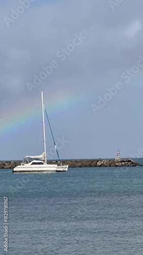 Rainbow over sailboat at Haleiwa Harbor on the Northshore of Oahu in the Hawaiian Islands. 