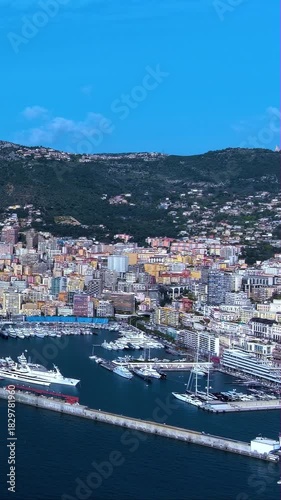 4K aerial vertical video of Monaco Port Hercule filled with luxury yachts. Cinematic drone footage of Monte Carlo skyline and Mediterranean coast. Ideal for travel reels and mobile stories.
