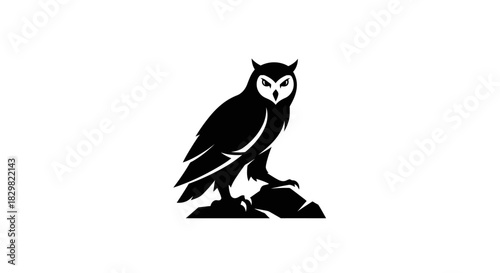 Majestic Owl Perched on Rock in Striking Silhouette.