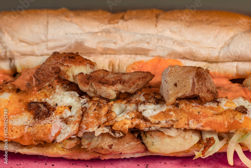 Long sandwiches with chicken breast, eggs, cabbage, cheese and dressing on plate