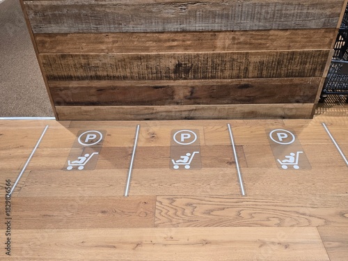 A high-angle view of a designated parking zone for baby strollers inside a shopping mall or retail store.