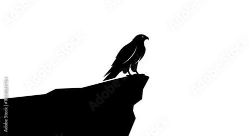 Black silhouette of a majestic bird of prey on a cliff edge.