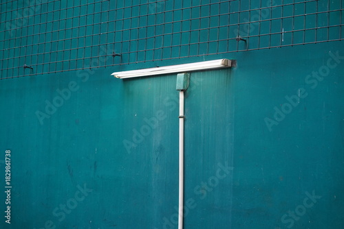 Minimalist Image of a Green Wall with Fluorescent Light Fixture and Water Dripping Effect Capturing Urban Aesthetics and Industrial Vibes