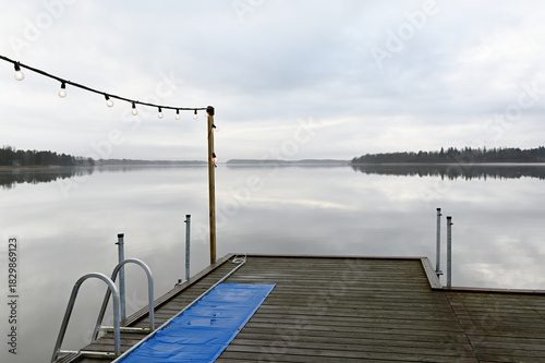 a wooden pier adorned with soft string lights, overlooking a perfectly still