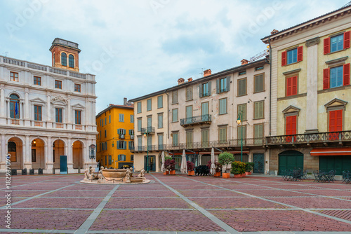 Fototapeta Naklejka Na Ścianę i Meble -  Colorful buildings and central fountain in Piazza Vecchia, Bergamo, Citta Alta, Lombardy, Italy. Italian old town square with medieval architecture. Travel destination in Italia