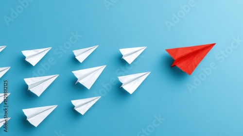 Red paper airplane leads white planes forward