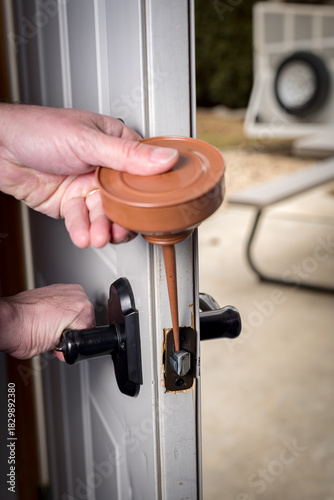 Homeowner oils a squeaky door in a garage
