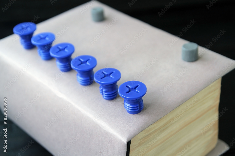 Naklejka premium Concept: a book as a key to knowledge, a thick paper book on an old dark wooden table. Books as a reservoir of fundamental scientific knowledge, books as the basis of education and enlightenment.