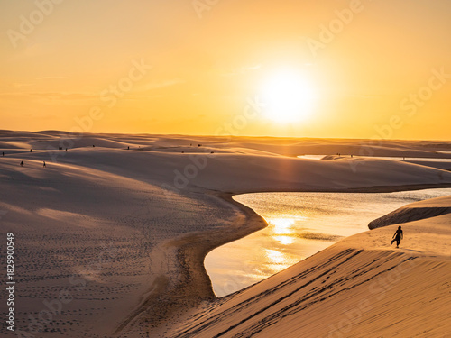 Stunning sunset over Lencois Maranhenses National Park with golden dunes, blue lagoons, and shifting warm colors, Maranhao, Brazil