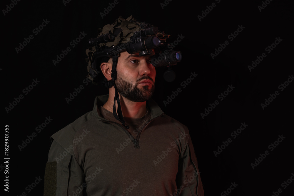 Fototapeta premium Portrait of bearded special forces soldier wearing helmet with night vision goggles isolated on black background for military concepts