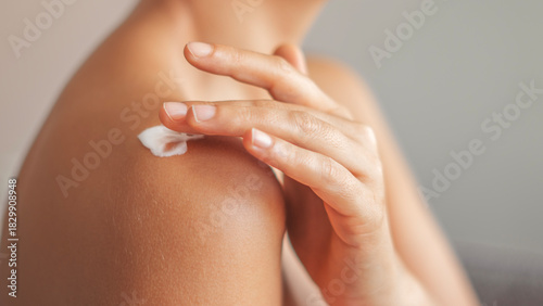Woman applying body cream on arm, beauty skin care concept