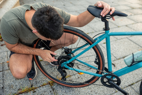Young man adjusting bicycle gears for outdoor cycling