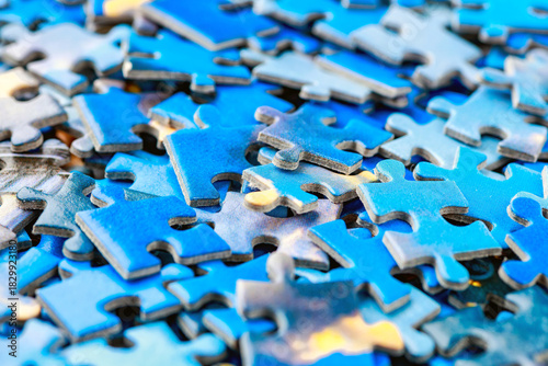 Jigsaw puzzle pieces.Colorful background with small puzzle pieces, messy.Some colored pieces of puzzle as background.Challenge and solution concept. Hobbies and leisure activities