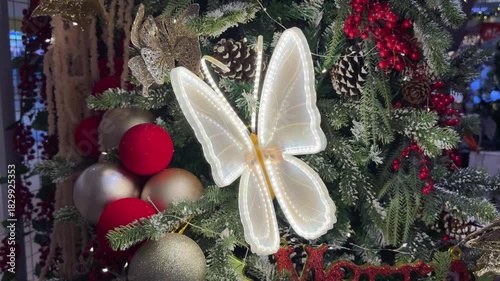 4k footage of illuminated butterfly shape christmas decoration. Interactive butterfly flapping its wings. Unique decoration and accessories on christmas tree. Beautiful Christmas and seasons greetings