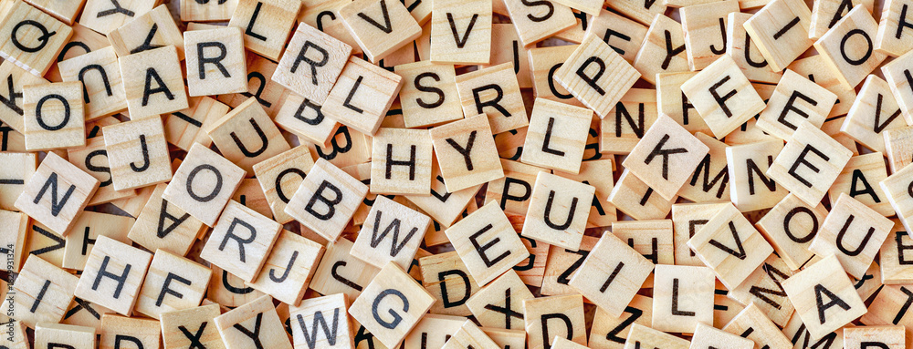 Obraz premium Alphabet letters on wooden block pieces, from above.Close up of Wooden letter cubes.Challenge and solution concept.Hobbies and leisure activities