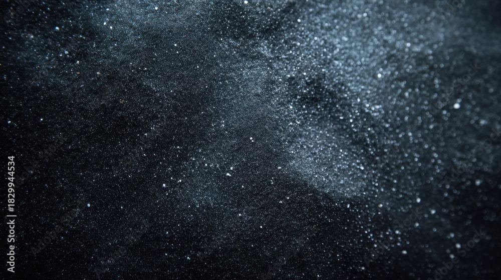 Obraz premium An abstract image showcasing a dark background scattered with fine particles resembling dust or smoke, creating an ethereal, mesmerizing effect.