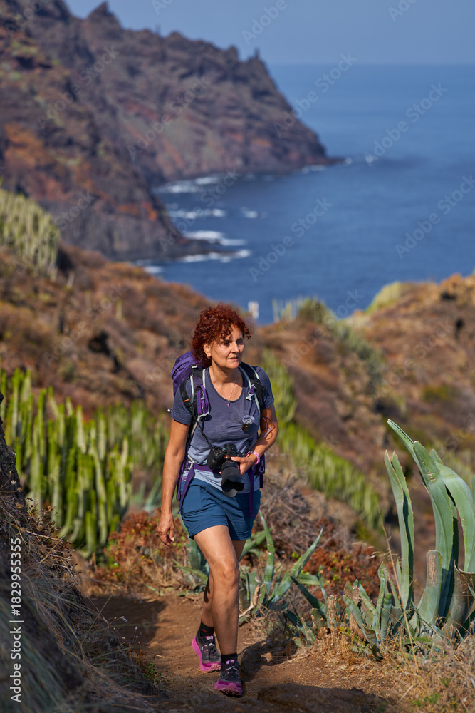 Naklejka premium Woman photographer hiking Anaga coast