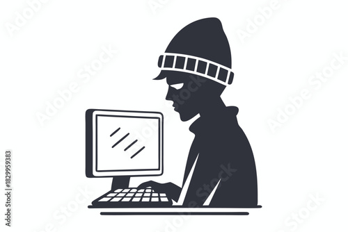 Male hacker with beanie types rapidly on the keyboard with an intense expression
