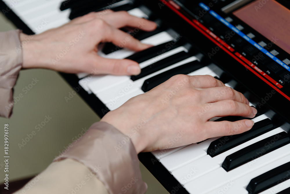 Obraz premium female pianist hands on black and white synthesizer keyboard, close-up view, young woman playing piano, professional musician