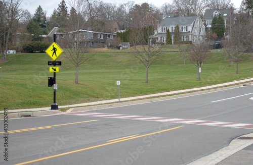Fotografi Wide angle view of a suburban pedestrian crosswalk with red and white striped ro